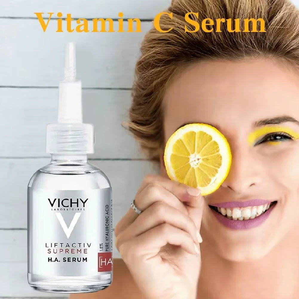 Vichy Liftactiv Supreme HA Serum bottle with a woman holding a lemon slice to her eye against a light wooden background.