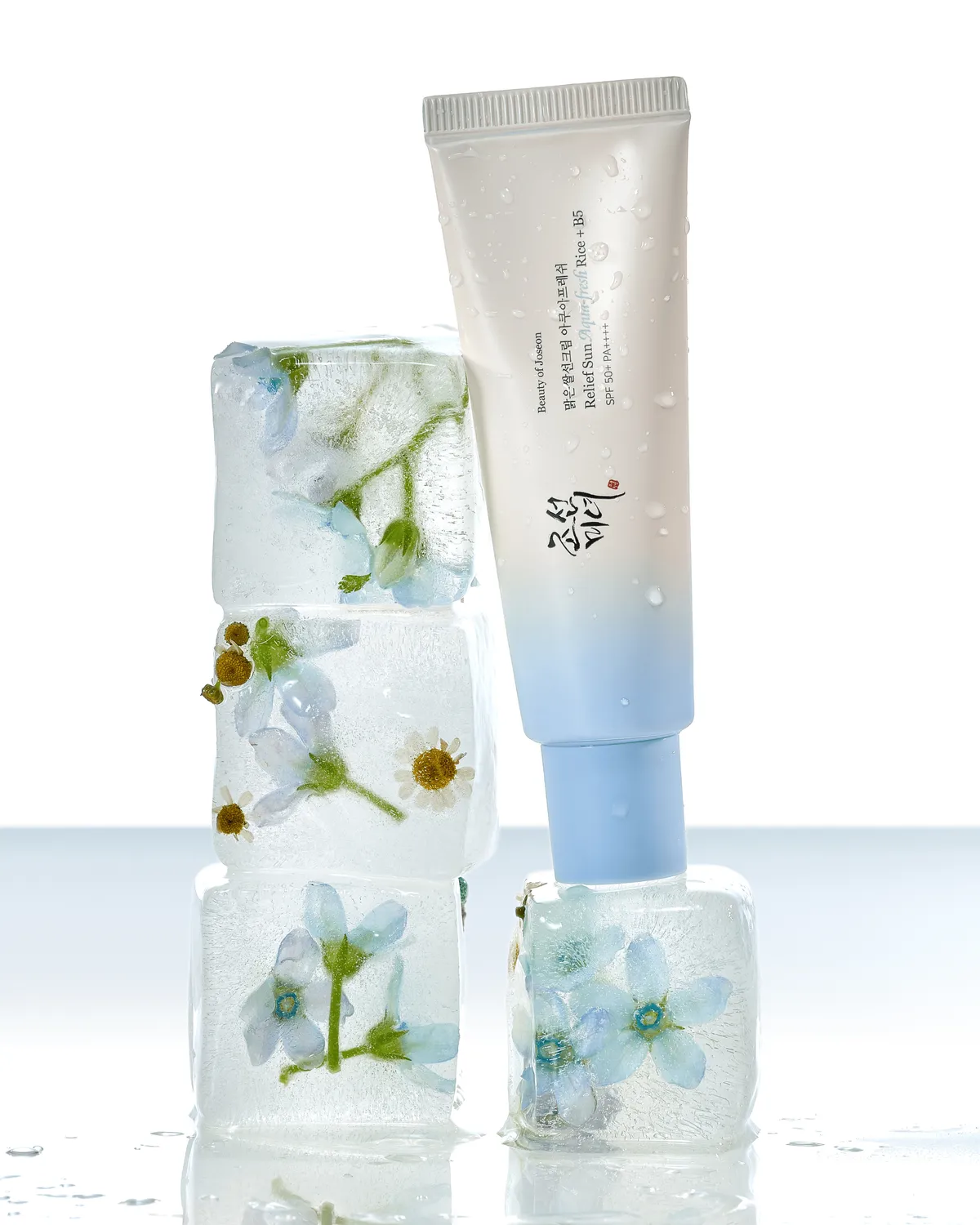 Relief Sun Aqua Fresh junto a cubos de hielo con flores