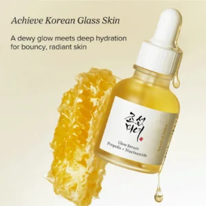 Glow Serum de Beauty of Joseon junto a un panal de miel y gotas de propóleo